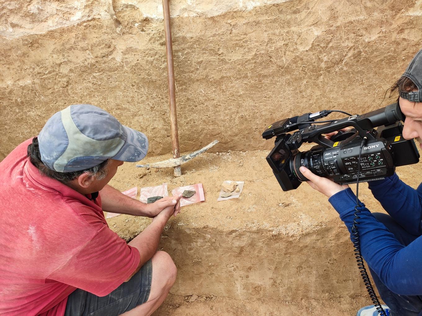 Антон Анойкин показывает телевизионикам находки с раскопа