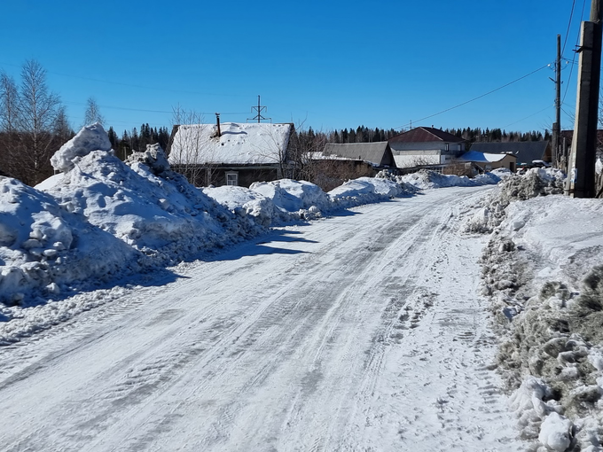 . Снегогрязевая пульпа, сдвинутая с проезжей части, в частном секторе в жилой зоне в городе Качканаре